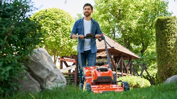 Un homme qui tond son jardin